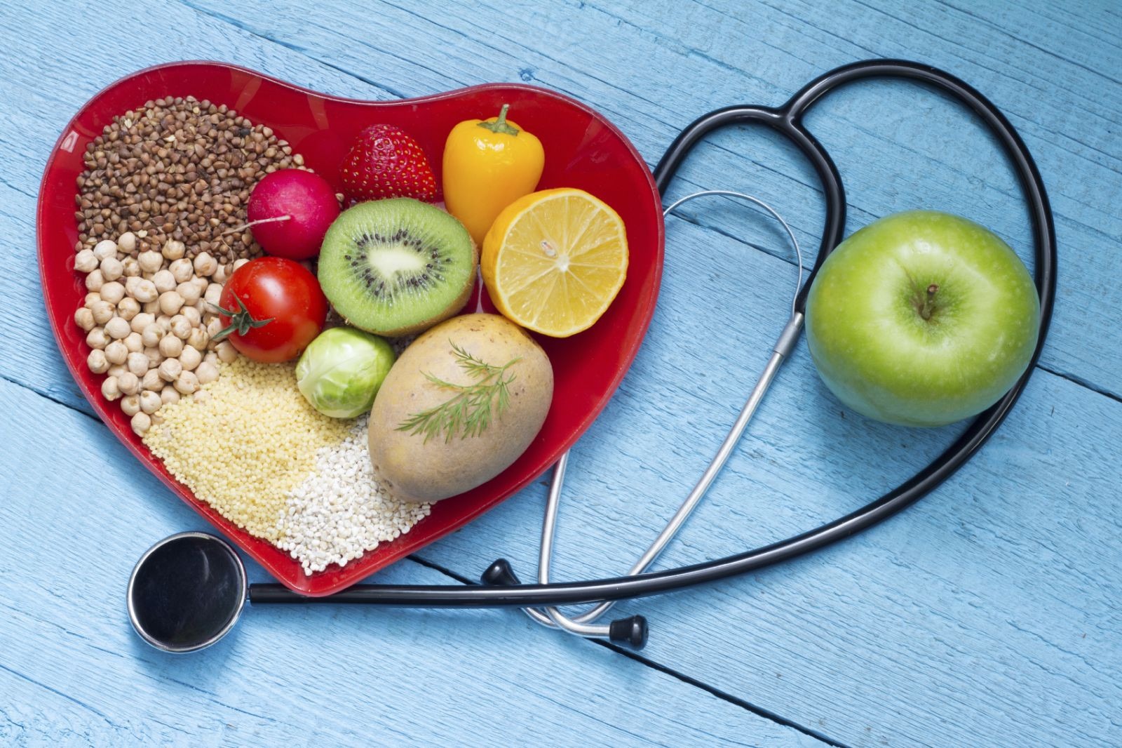 Healthy foods in a heart shape with a stethoscope, representing heart health